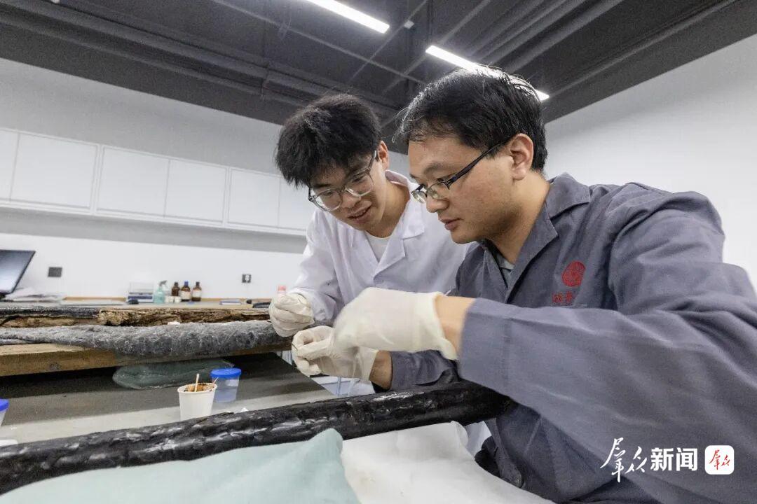 石卓辉(左)跟随老师修复漆器。